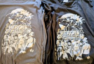 Two Heroes Convention screen pressed tee shirts grey and black. The grey one has a misprint and was included with the purchase.