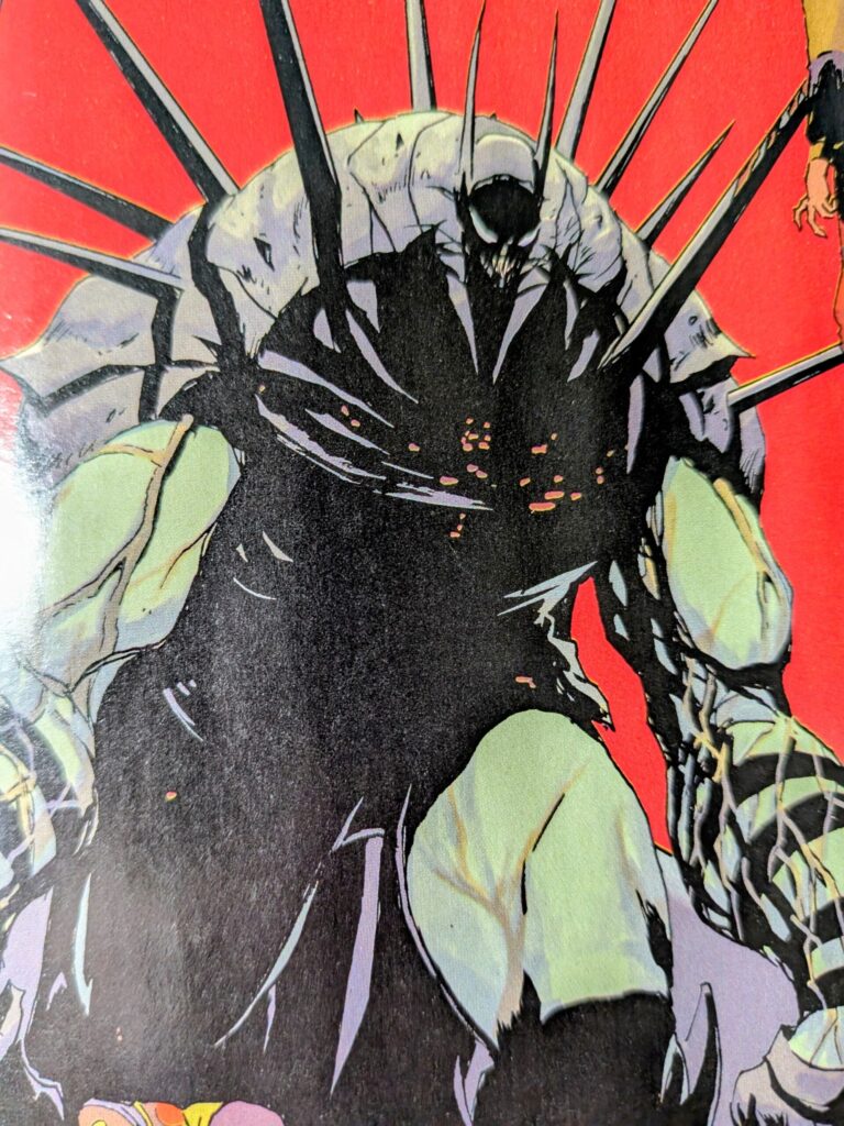 Absolute Clayface in the form of Absolute Batman with spikes extended, outside of the panel he is fighting two Absolute Robins.